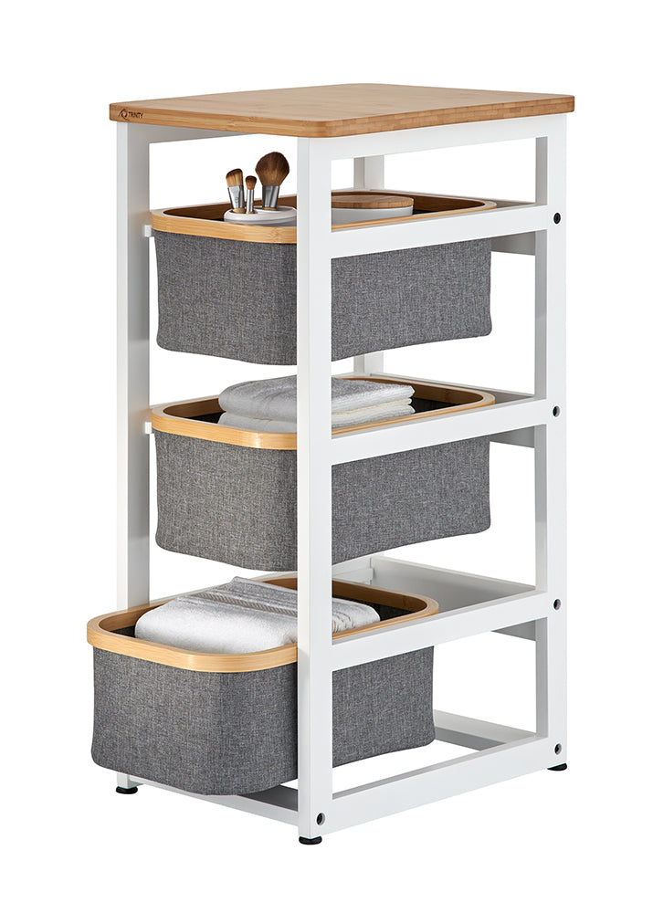 A multi-tiered storage organizer features a white metal frame with a light wood tabletop and three pull-out grey fabric bins. Each bin is accented with a wooden rim and holds various bathroom essentials, including makeup brushes, towels, and toiletries.