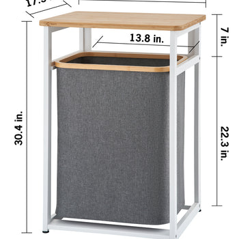 A white metal hamper frame with a light wooden tabletop holds a dark gray fabric laundry bin inside. Dimension markings show overall outer measurements of 21.1 inches wide, 17.3 inches deep, and 30.4 inches total height, alongside secondary callouts detailing a 7-inch clearance above the hamper opening, a 13.8-inch inner width gap, and a 22.3-inch tall hamper section.