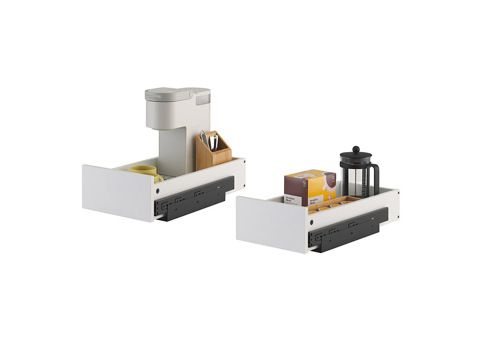 Two white pull-out cabinet drawers featuring black sliding mechanisms are shown against a plain white background. The left drawer holds a single-serve coffee maker and mug, while the right drawer is organized with a French press, coffee pod holder, and a box of coffee.