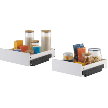 Two white pull-out organizer drawers equipped with black side-mounting tracks are filled with pantry items against a plain background. The left drawer holds tall glass storage canisters and food boxes, while the right drawer contains snack pouches, cookie jars, and a tin of wafer sticks.