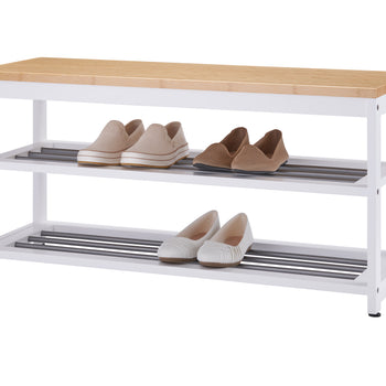 A white three-tier shoe rack with a light wood top. Four pairs of shoes, including tan slip-ons and white and brown woven flats, are neatly stored on the two shelves.