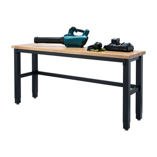 A workbench with a light-colored wooden top and black metal legs stands against a white background. Several power tools, including a teal leaf blower and a battery charger with batteries, rest on the tabletop.