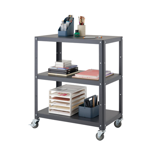 A dark gray metal utility cart with three shelves is shown against a white background. The cart is filled with various office and art supplies, including notebooks, pens, and paper organizers.