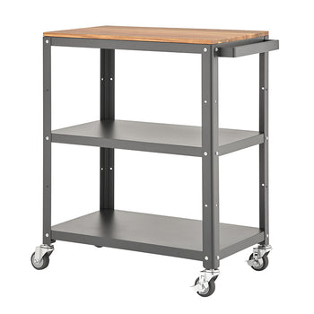 A functional, three-tier utility cart with a dark grey metal frame and a light brown, wooden top surface. The cart is on four swivel caster wheels, featuring two lower open metal shelves and a handle on the right side for easy mobility.
