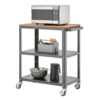 A three-tiered rolling utility cart with a dark gray metal frame and a light wood top shelf. A stainless steel microwave sits on the top, and the two lower shelves hold various kitchen items like bowls, a thermos, and a utensil caddy.