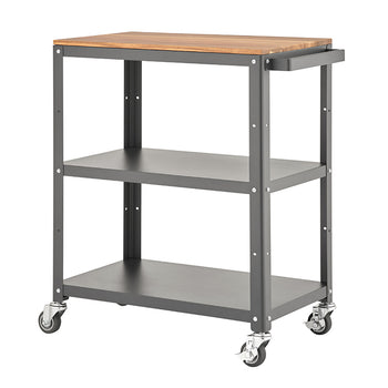 A functional, three-tier utility cart with a dark grey metal frame and a light brown, wooden top surface. The cart is on four swivel caster wheels, featuring two lower open metal shelves and a handle on the right side for easy mobility.