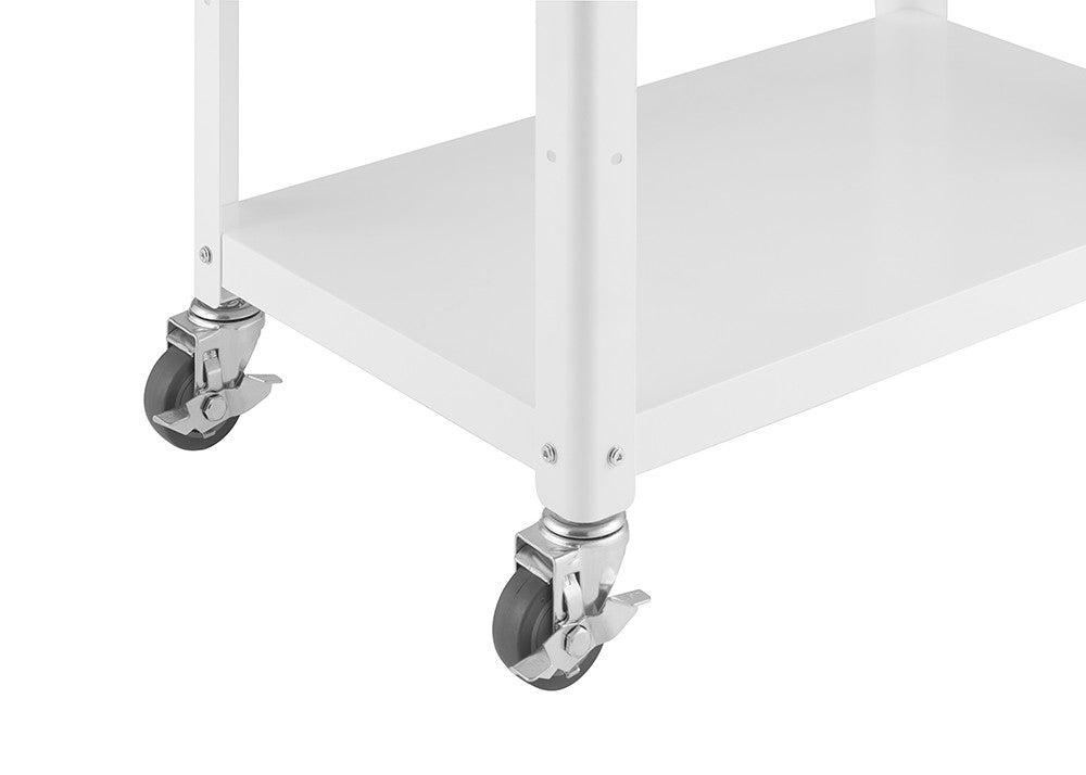 A close-up shot shows the bottom corner of a white metal kitchen cart. Two wheels with gray rubber tires and silver metal casters are visible, one with a locking mechanism engaged. The cart has a flat, white metal shelf above the wheels.