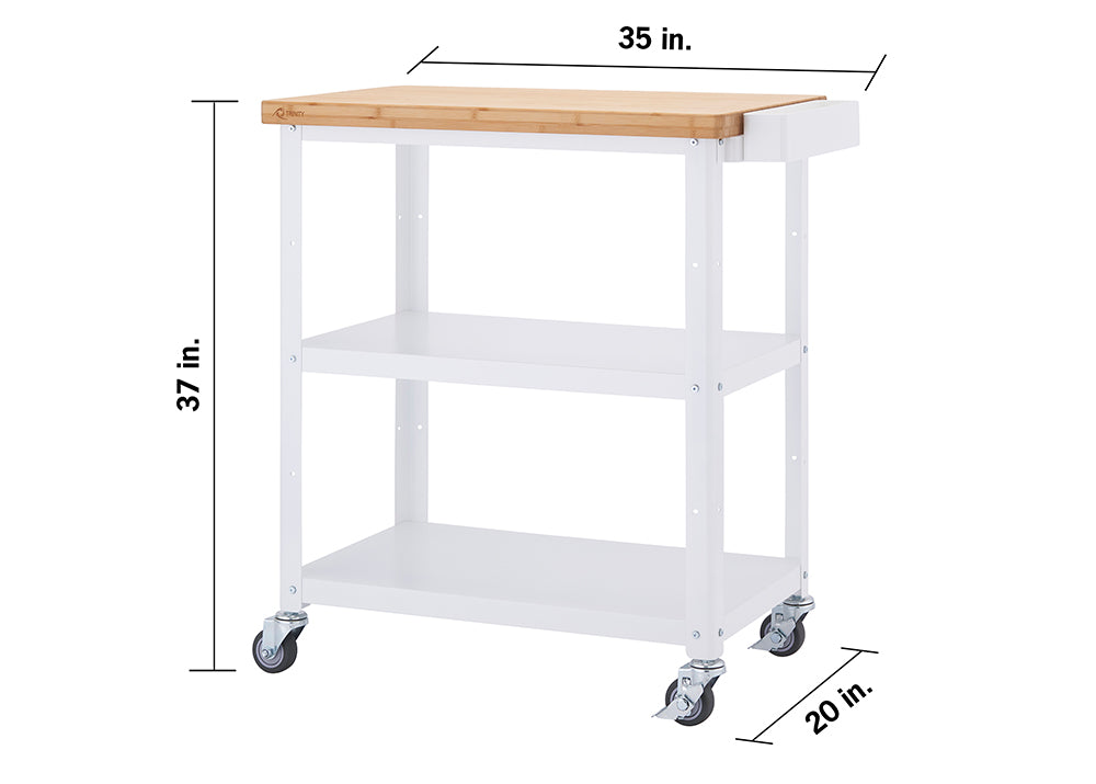 A front-facing view of a white Trinity kitchen cart with a light brown bamboo top. The cart has two shelves below the top surface and is on four wheels, with dimensions of 37 inches high, 35 inches wide, and 20 inches deep.