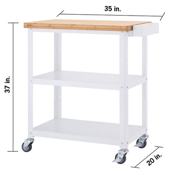 A front-facing view of a white Trinity kitchen cart with a light brown bamboo top. The cart has two shelves below the top surface and is on four wheels, with dimensions of 37 inches high, 35 inches wide, and 20 inches deep.