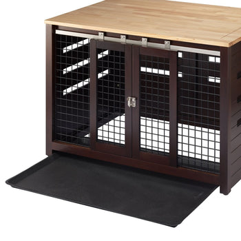 A brown wooden pet crate with a light brown wooden top functions as an accent table. The crate features sliding metal doors and a black plastic tray that has been partially pulled out from underneath.