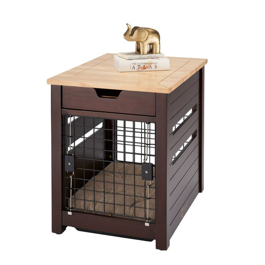 A dark brown wooden pet crate end table features a wire door and side slats for ventilation. The light brown tabletop holds a book titled "ATLAS" and a small gold elephant figurine.