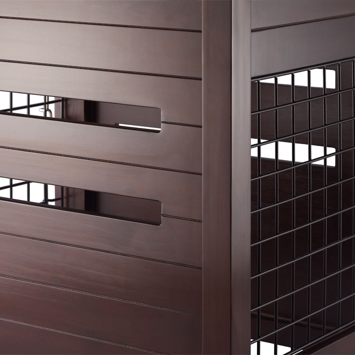 A close-up shot shows the textured brown slats of an outdoor furniture piece alongside a section of black wire mesh. The slats run horizontally with small rectangular openings, contrasting with the grid pattern of the adjacent mesh.