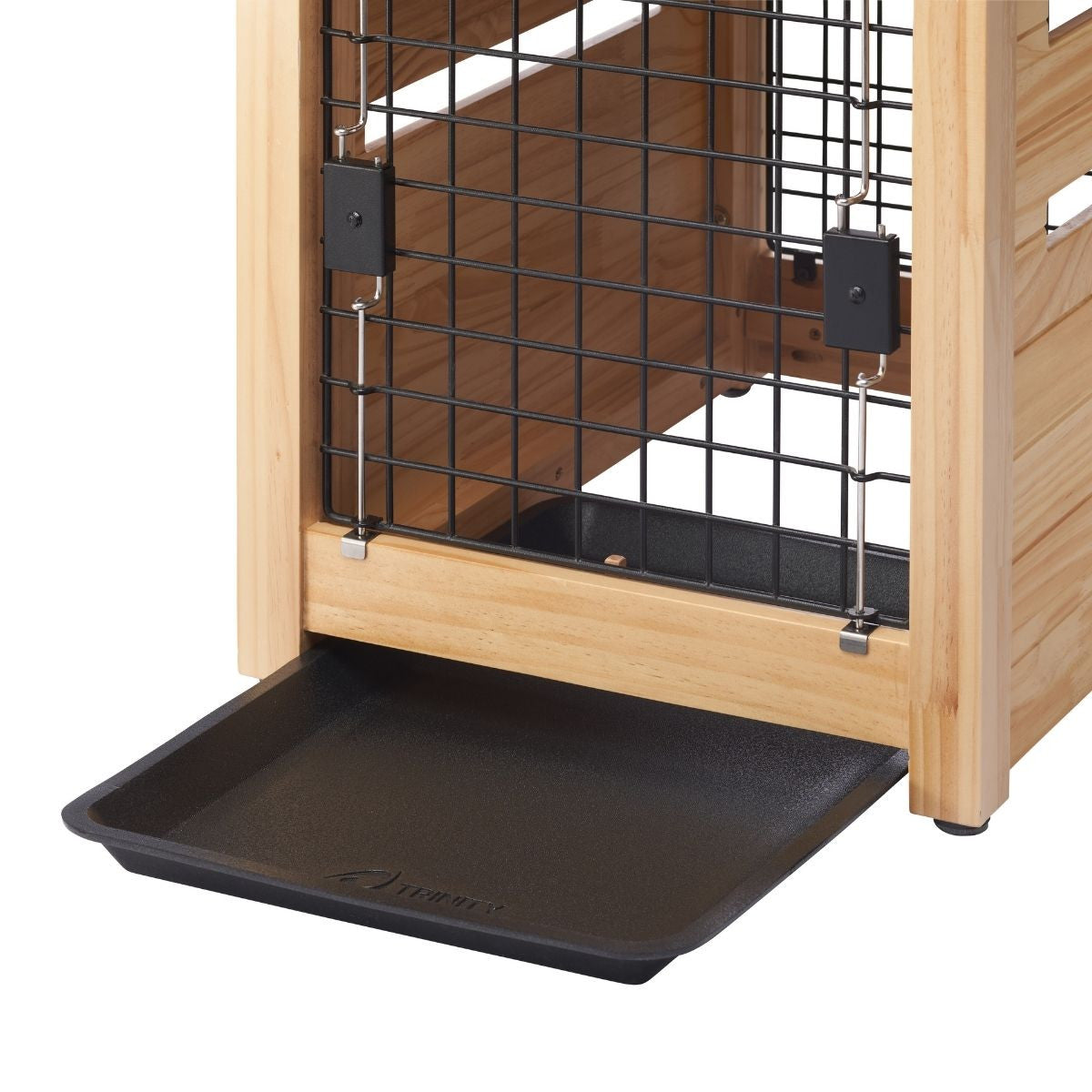 A close-up shot shows a partially extended black plastic tray beneath a wooden pet crate with black wire bars. The tray slides out from the bottom of the crate, which appears to have a door secured with latches.
