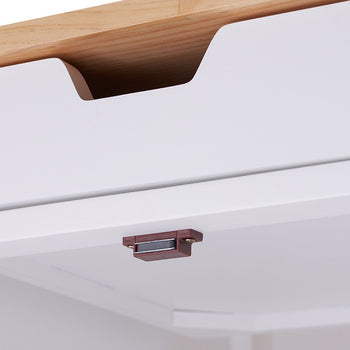A close-up shot of a white drawer with a brown magnetic catch on the underside of the top panel. The drawer features a cutout handle and is partially open, revealing a glimpse of the interior.