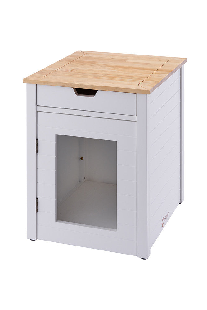 A white, square cat litter box enclosure with a light wood top is shown at a slight angle. It features a drawer at the top and a door with a clear panel on the front, revealing the interior.