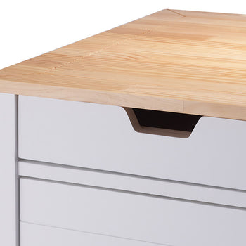A close-up shot of a light wood countertop on a white cabinet. The cabinet features a drawer with a modern, recessed handle.