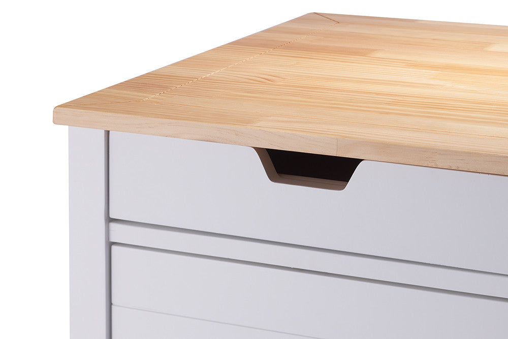 A close-up shot of a light wood countertop on a white cabinet. The cabinet features a drawer with a modern, recessed handle.