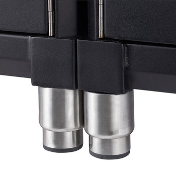 Close-up of two cylindrical stainless steel legs supporting a black cabinet. The legs have black, conical feet, and the cabinet itself appears to be made of a dark, possibly metallic, material.