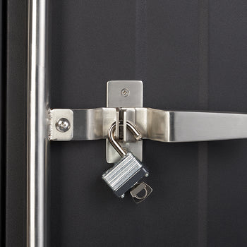 A close-up shot shows a shiny silver padlock with its key still inserted, hanging unlocked from the latch of a metal door handle. The handle itself is also silver and secured to a dark grey or black door.