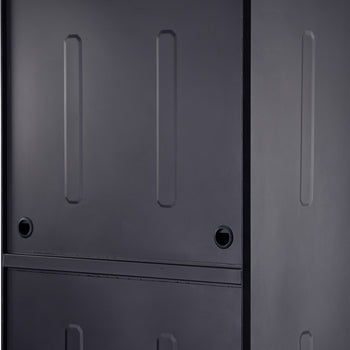 A close-up shot shows a dark grey or black metal surface, possibly a cabinet or appliance, with subtle raised rectangular designs. Two circular, dark holes are visible on the surface, one on the left and one further to the right.