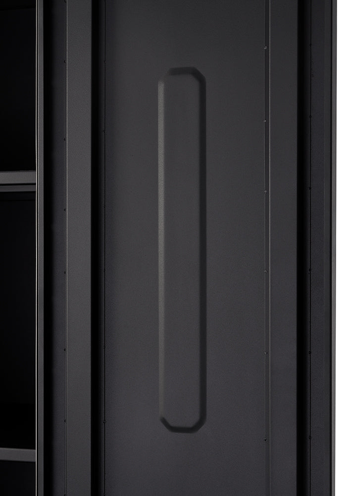 A close-up shot shows a dark gray, possibly metal, panel with a raised, elongated hexagonal shape running vertically down its center. To the left, a darker, recessed area with two horizontal shelves is partially visible.