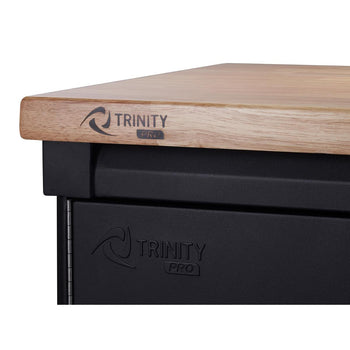 A close-up shot shows the corner of a black Trinity PRO garage storage unit with a light brown wooden countertop. The 