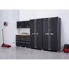 A well-organized garage setup features a Trinity PRO 8-Piece Garage Cabinet Drawer Set in black consisting of 2 locker cabinets 2 wall cabinets, 3 base cabinets with drawers, a 56 inches wide wood top. Various garage items, including a red floor jack, a brake rotor, and a red air compressor, are also visible in the spacious, light-grey floored area.