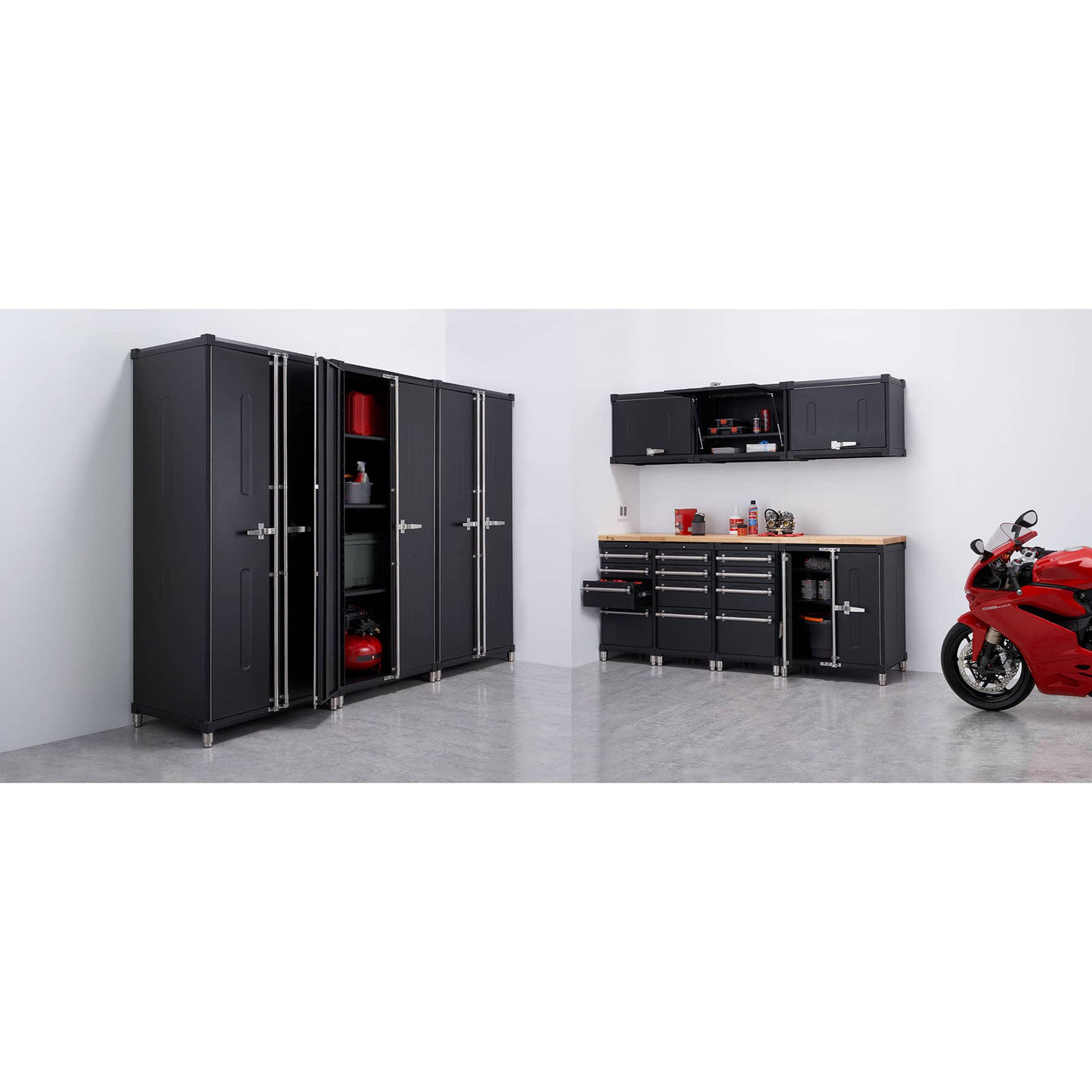 This wide shot shows a black Trinity PRO 11-Piece Garage Cabinet Set installed in a garage with a red motorcycle parked to the right. The set includes tall locker cabinets, base cabinets with a wooden countertop, and wall-mounted cabinets, offering ample storage space.