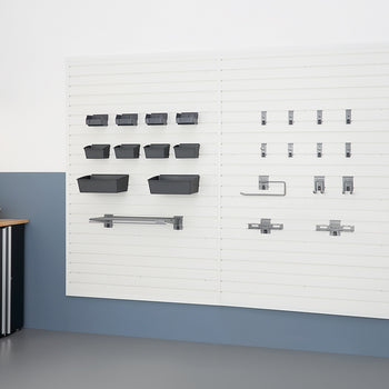 A clean and organized garage wall features white slatwall panels. Various storage accessories are mounted, including gray bins of different sizes on the left and an assortment of hooks, hangers, and a paper towel holder on the right.
