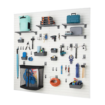 A well-organized white slatwall system displays various tools and household items in a garage or workshop. Shelves, hooks, and bins hold everything from power drills and hammers to an umbrella and an extension cord, demonstrating efficient storage.