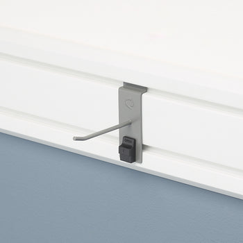 A single gray hook is attached to a white slatwall. The hook has a black locking mechanism at its base, which is labeled 