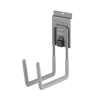 
A grayscale image shows a Trinity brand wall-mounted J-hook, designed for garage or workshop organization. The hook is made of metal with a gray, non-slip coating on the two prongs and features a press-and-lock mechanism to secure it to a wall rail.