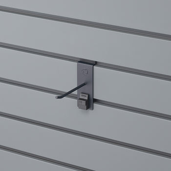 A close-up shot shows a grey slatwall panel with a dark grey security display hook attached. The hook has a small 