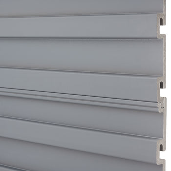 A close-up shot shows several horizontally stacked, light gray slatwall panels. The panels interlock with a tongue and groove system visible on the right edge.