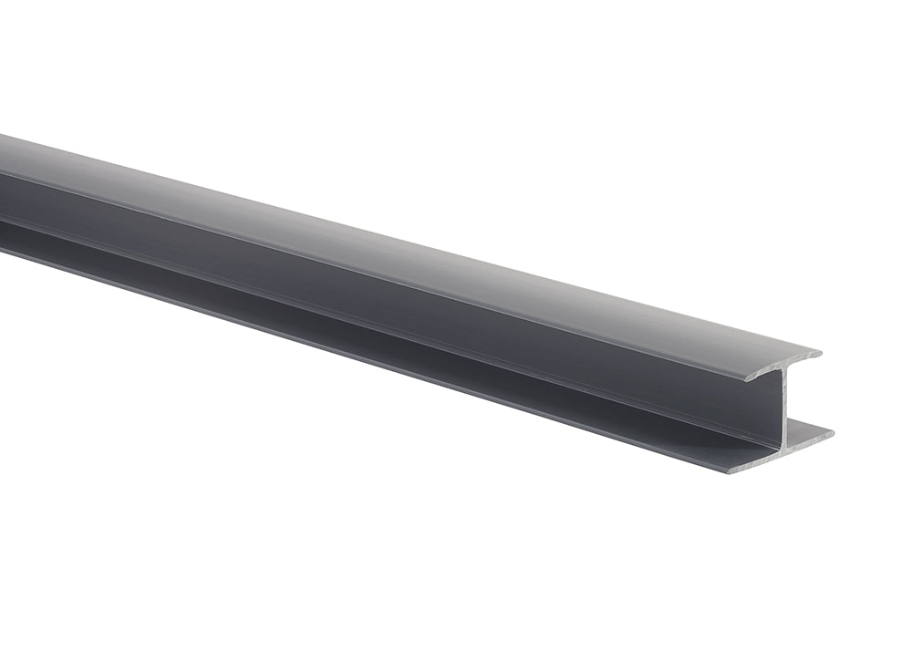A long, gray I-beam or H-beam is positioned diagonally across a white background. The metal beam has a smooth finish and is lit from the front, highlighting its distinct cross-sectional shape.