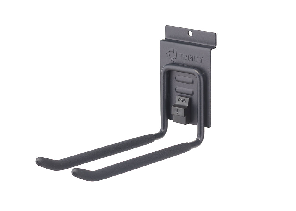 A close-up shot shows a black Trinity garage hook designed for hanging tools or equipment. The hook features two padded arms extending from a wall-mounted bracket with the Trinity logo and an "OPEN" indicator.