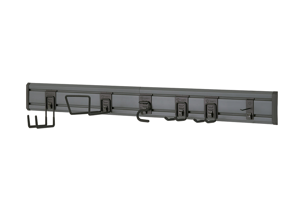 A wall-mounted gray garage organization system features a long track with various hooks and brackets attached. The hooks are designed to hold different types of tools and equipment, including a wide bracket for larger items, several smaller U-shaped hooks, and a single hook at the end.