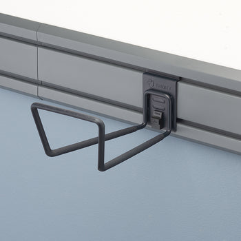 A close-up shot of a gray storage hook attached to a gray wall-mounted rail system. The hook has two prongs extending outward, and a 