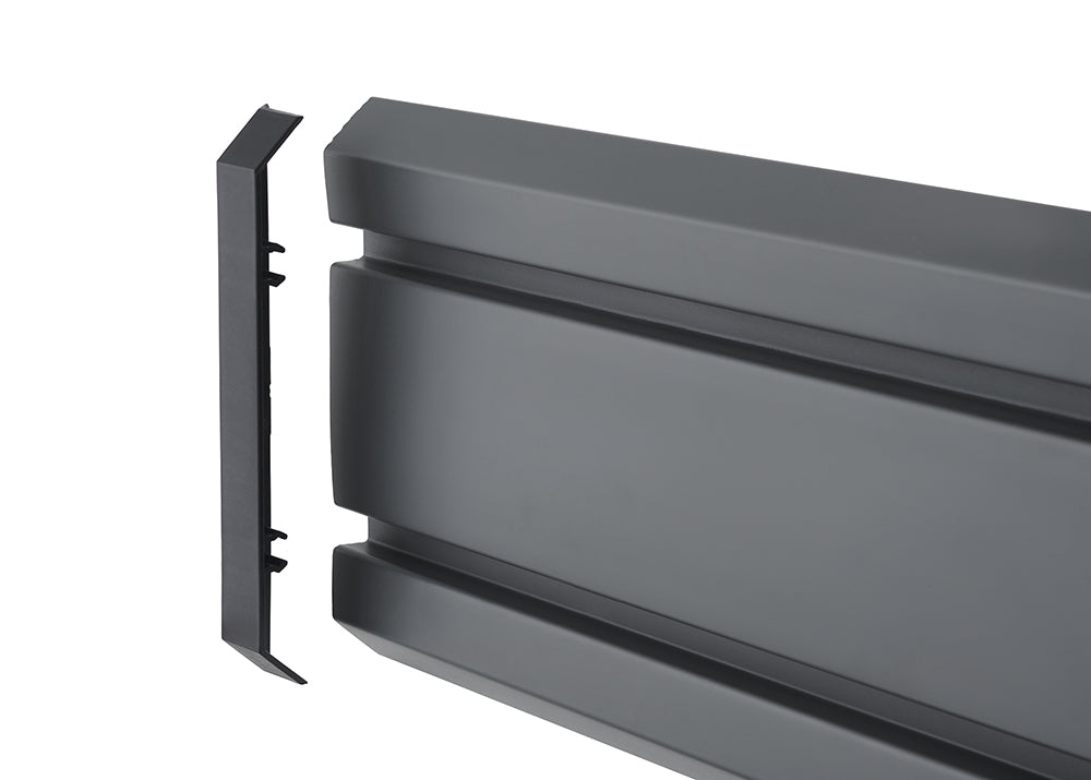 A high-angle product shot shows a matte black, grooved, plastic car running board with a separate end cap. The end cap, which is slightly beveled at the top and bottom, is positioned to the left of the main running board, ready to be attached.
