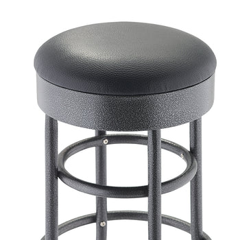 A close-up of the top of a bar or counter stool shows a round, padded seat covered in black textured faux leather. The seat rests on a black, speckled metal base with tubular legs and footrings.