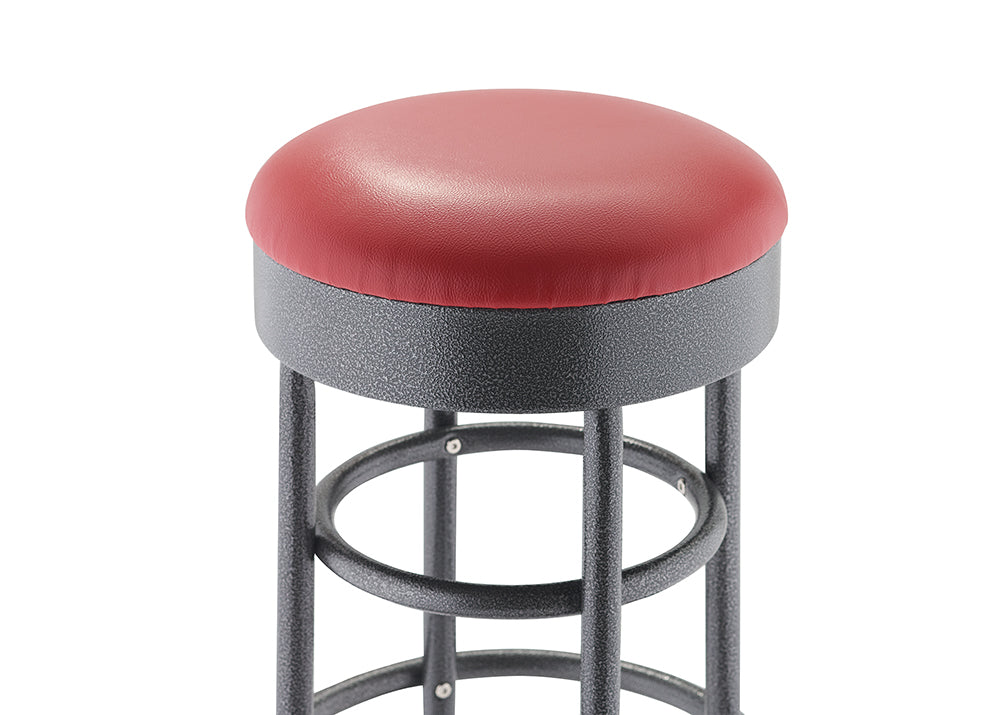 A close-up shot focuses on the seat of a round bar stool with a dark red, cushioned top. The base is a black, textured metal with visible circular supports and legs.