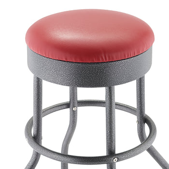 A close-up of a bar stool featuring a red, round, upholstered seat. The stool has a textured, speckled black metal frame with a circular footrest.