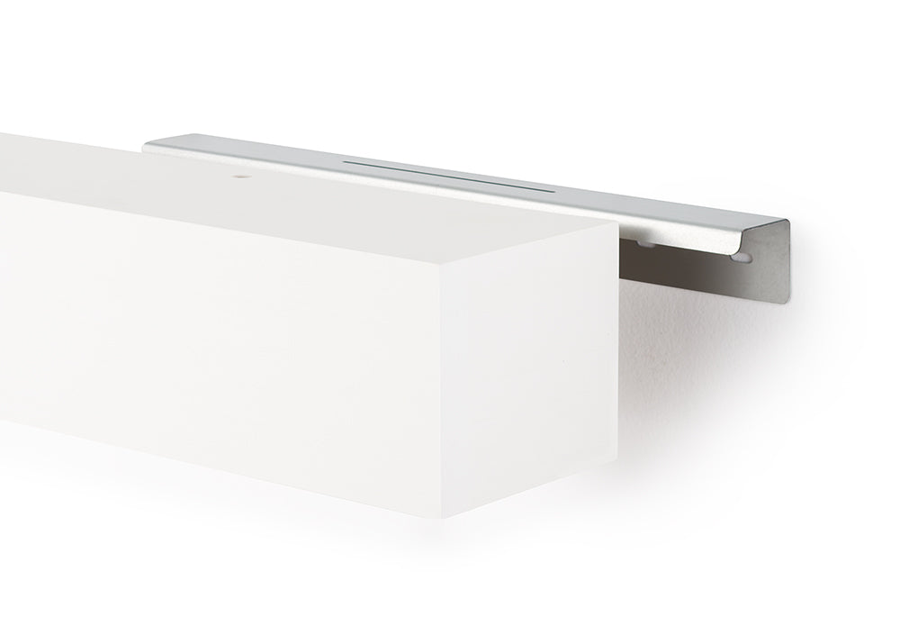 A white floating shelf is shown partially slid onto a sleek, silver metal wall bracket. The image highlights the mounting mechanism against a clean, white background.
