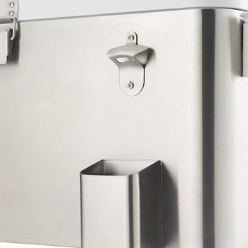 A close-up shot of a stainless steel cooler shows a built-in bottle opener and a small, rectangular storage bin attached to its side. The cooler has a shiny, brushed metal finish and a white lid that is partially visible at the top.