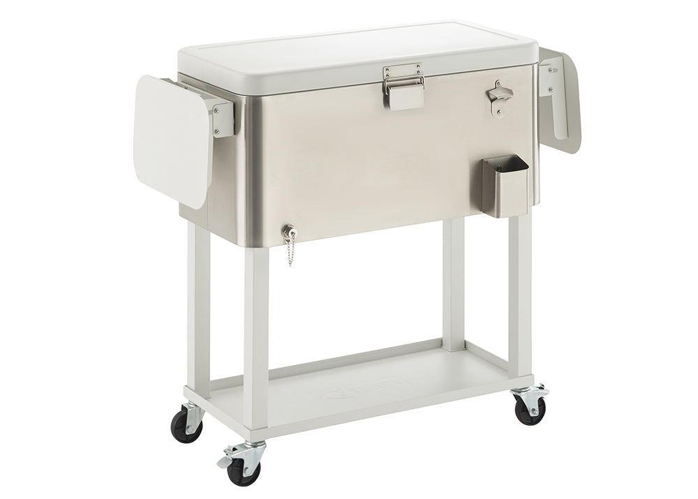 A rectangular, brushed stainless steel cooler with a white lid sits on a white metal cart with wheels. The cooler has an attached bottle opener, a small side caddy, and two fold-out white side tables.