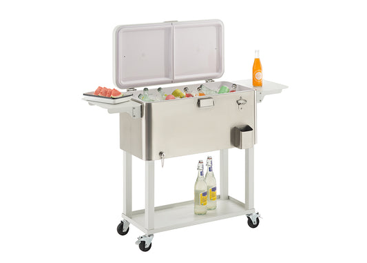 A stainless steel outdoor cooler on wheels with its lid open, revealing a variety of drinks on ice. The cooler has two side tables, one holding a plate of watermelon slices and the other an orange soda bottle, with two more bottled drinks on a shelf below.