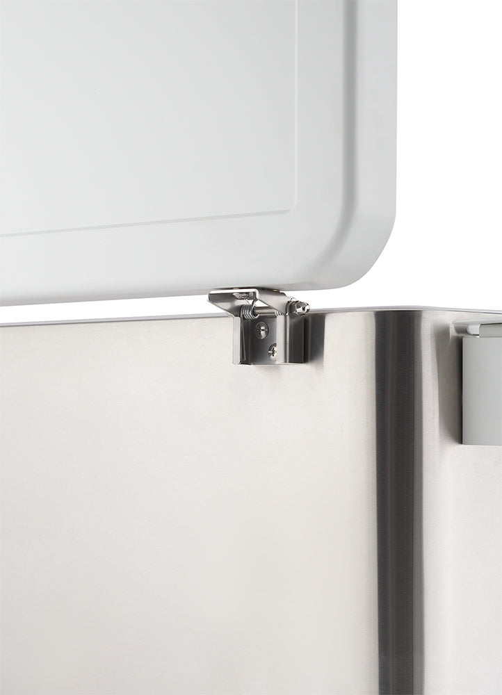 A close-up shot shows a shiny, metallic hinge connecting a white lid to a stainless steel appliance. The hinge is partially visible, with the lid slightly ajar, revealing the mechanical connection.