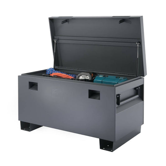 An open Trinity job site box is shown, revealing tools and equipment stored inside. The heavy-duty steel chest features a lid supported by gas struts and handles on the sides, designed for secure storage on a job site.