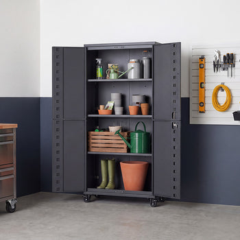 An open dark gray metal storage cabinet is neatly arranged with gardening supplies, including watering cans, terracotta pots, plant sprayers, a wooden crate, and tall boots. Set in a workshop space with a wall-mounted tool board and rolling metal workbench, the unit features wide-opening double doors and caster wheels for easy mobility.