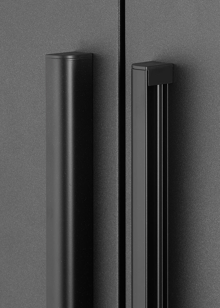 A close-up shot highlights the sleek, matte black vertical door handles mounted on a dark gray powder-coated steel cabinet. The detailed view showcases the modern, ergonomic handle design and clean textured finish.